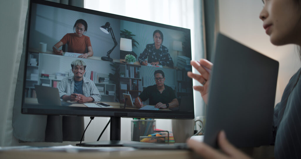 Portrait back view of businesswoman makes video conference meetings with the team online and presents work projects with a laptop. Work from home concept.